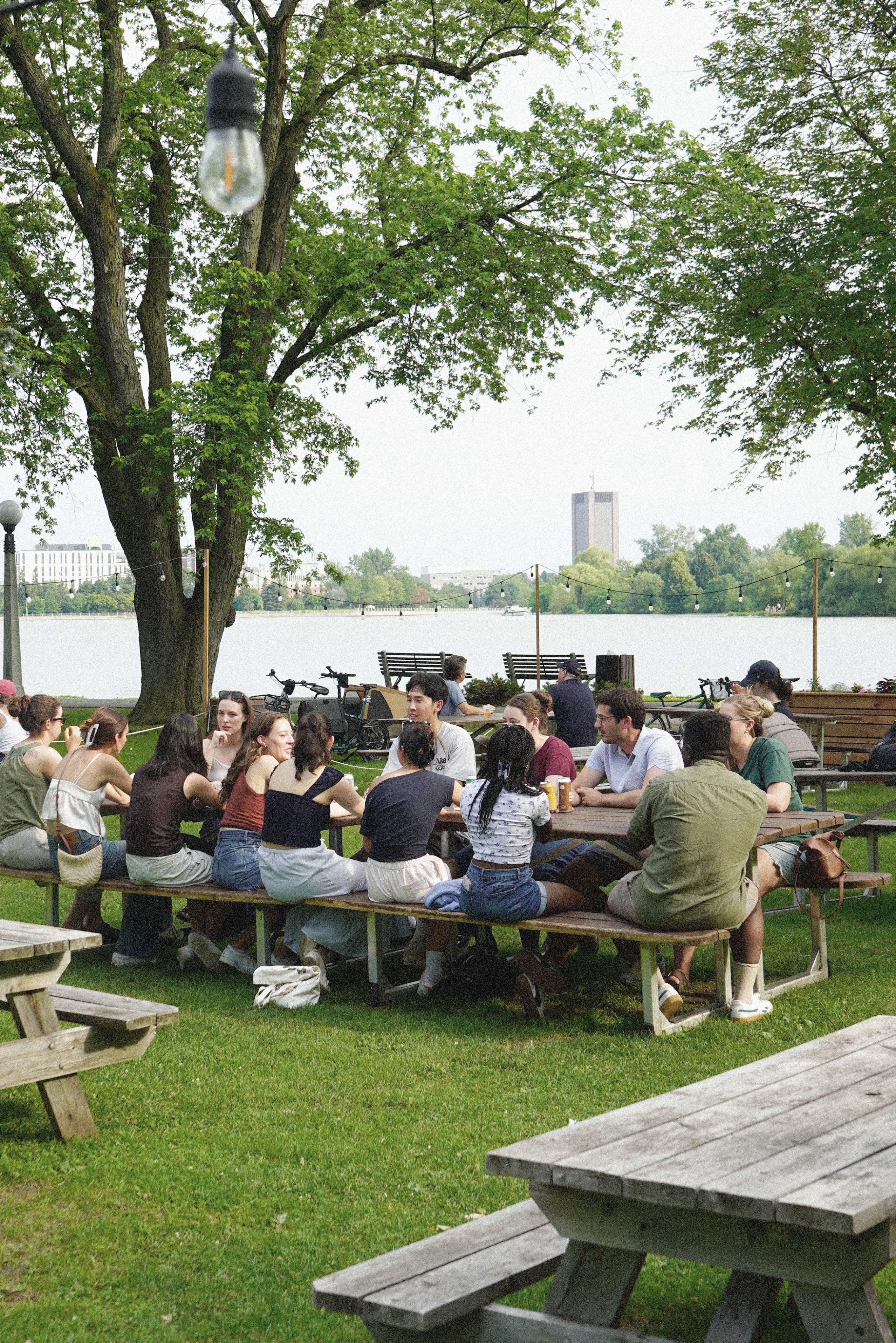 A crowd gathered at picnic tables by the water at Bar Lakeside, Dow’s Lake